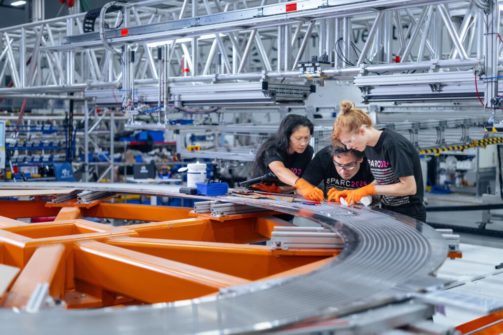 Three CFS employees working on magnet inside the CFS Magnet Factory