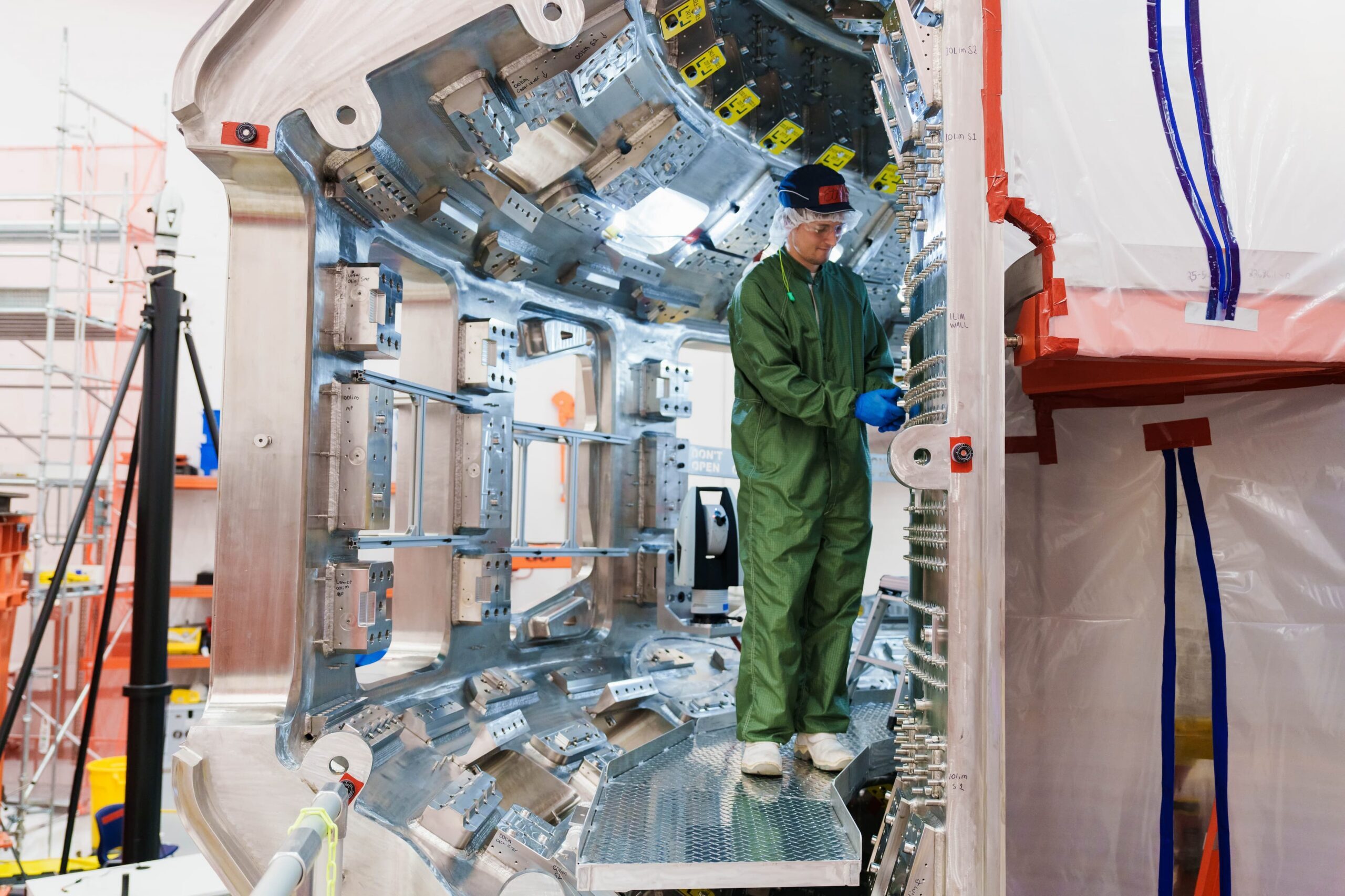 A CFS technician works inside the newly arrived vacuum vessel half inside tokamak hall